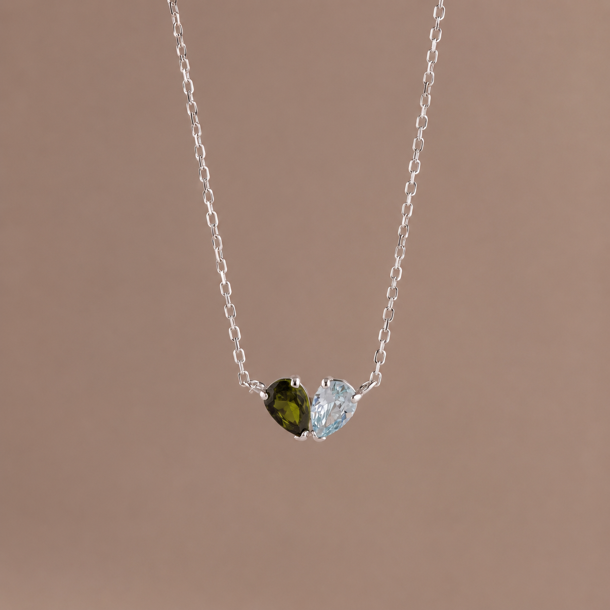 Necklace with two heart-shaped gemstones on a brown background
